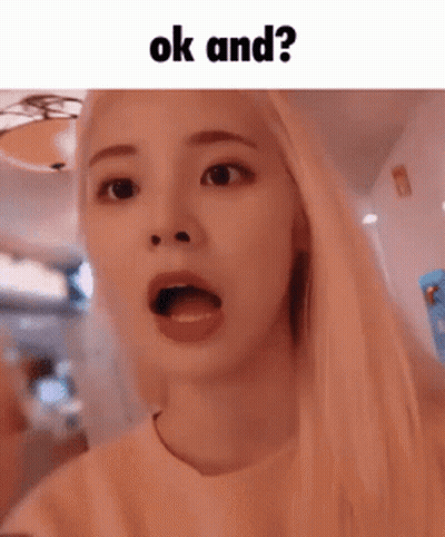A Girl With Blonde Hair Is Making A Funny Face With Her Mouth Open And The Words Ok And ? Above Her . GIF