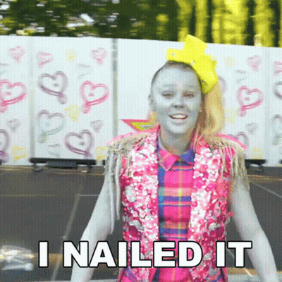 A Girl With Blue Paint On Her Face Is Standing In Front Of A Wall That Says I Nailed It . GIF