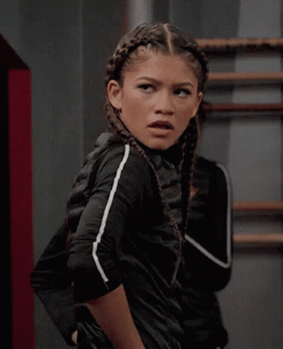 A Girl With Braids In Her Hair Is Wearing A Black Jacket GIF