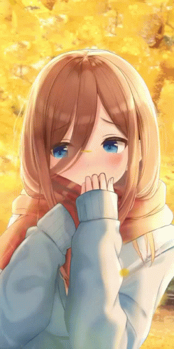 A Girl With Brown Hair And Blue Eyes Is Covering Her Face With A Scarf GIF