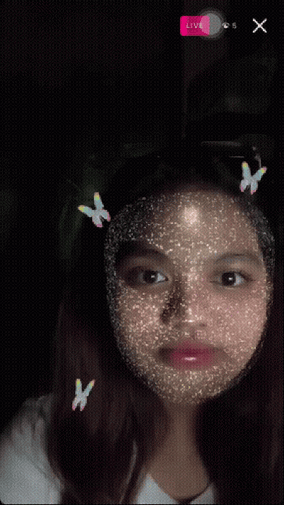 A Girl With Butterflies On Her Face And A Live Button On The Bottom Right GIF