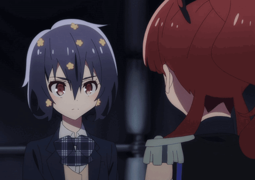 A Girl With Flowers In Her Hair Looks At Another Girl With Red Hair GIF