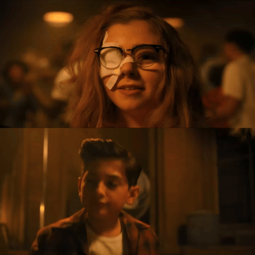 A Girl With Glasses And A Bandage On Her Nose Is Next To A Boy Holding A Stick GIF