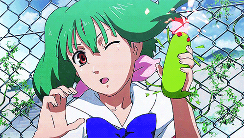 A Girl With Green Hair Is Standing In Front Of A Chain Link Fence Holding A Green Object GIF