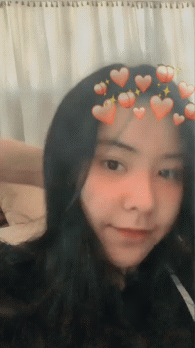 A Girl With Hearts On Her Head Is Smiling GIF
