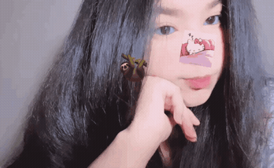 A Girl With Hello Kitty Stickers On Her Face GIF