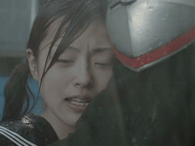 A Girl With Her Eyes Closed Is Being Comforted By A Person Wearing A Helmet GIF