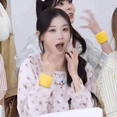 A Girl With Her Mouth Open And A Yellow Wristband Around Her Wrist . GIF
