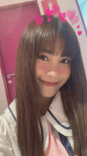 A Girl With Long Hair And Hearts On Her Head Smiles For The Camera GIF