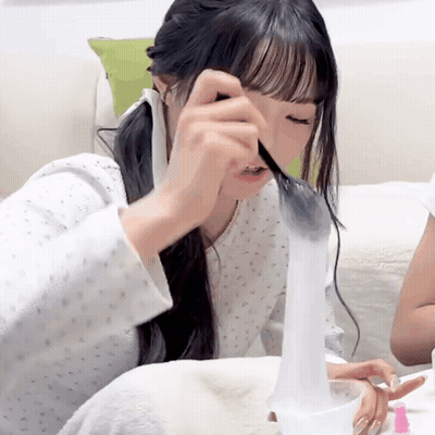 A Girl With Long Hair Is Playing With A Toy GIF