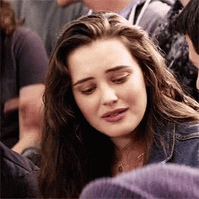A Girl With Long Hair Is Sitting In A Crowd Of People And Looking Down . GIF