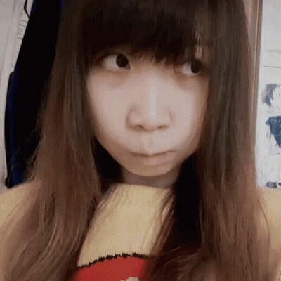 A Girl With Long Hair Is Wearing A Yellow And Red Sweater And Making A Face GIF