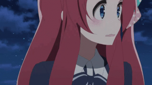 A Girl With Long Red Hair And Blue Eyes Looks At The Camera GIF