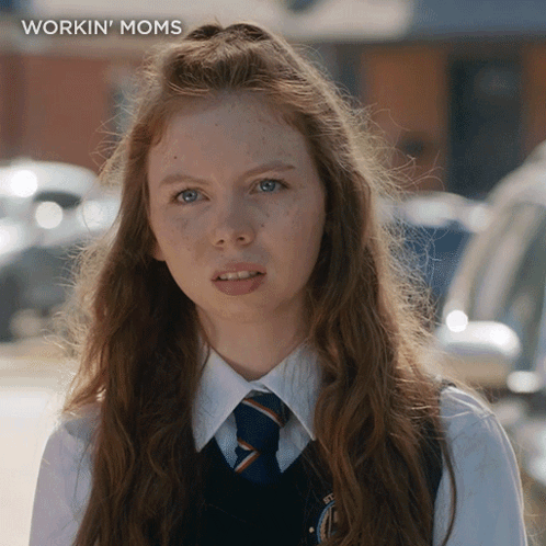 A Girl With Long Red Hair Is Wearing A Workin ' Moms Shirt GIF
