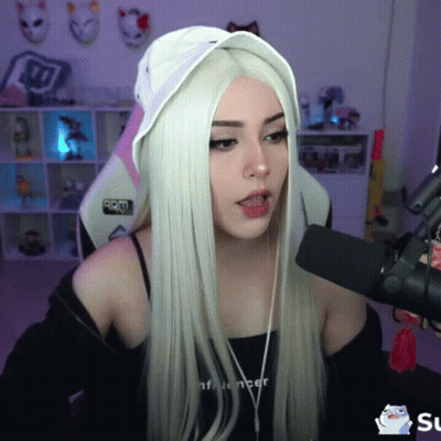 A Girl With Long White Hair Is Talking Into A Microphone While Wearing A Black Top That Says Influencer GIF