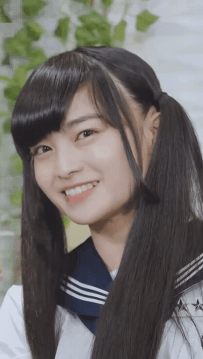 A Girl With Pigtails And A Sailor Uniform Smiles For The Camera GIF