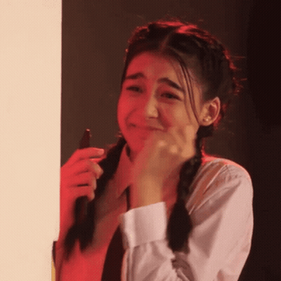 A Girl With Pigtails Is Crying While Holding A Cell Phone In Her Hand . GIF