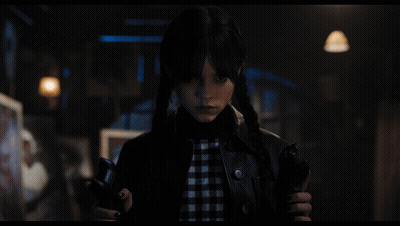 A Girl With Pigtails Is Holding A Gun GIF