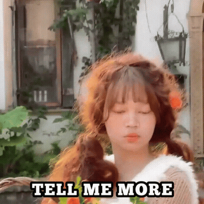 A Girl With Pigtails Is Standing In Front Of A Building And Says Tell Me More . GIF