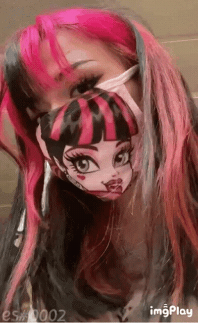 A Girl With Pink And Black Hair Is Wearing A Monster High Mask . GIF