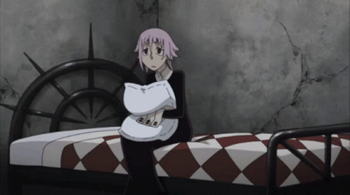 A Girl With Pink Hair Is Sitting On A Bed GIF