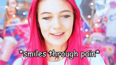 A Girl With Pink Hair Is Smiling With The Words * Smiles Through Pain * Below Her GIF