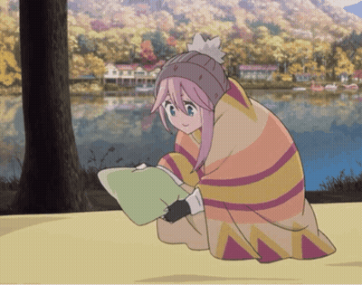 A Girl With Pink Hair Is Wrapped In A Blanket And Reading A Book GIF