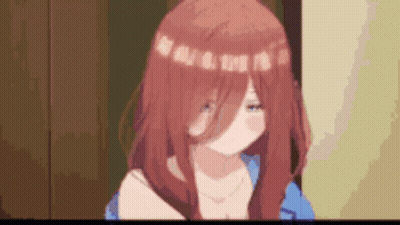 A Girl With Red Hair And A Blue Shirt Is Standing In A Room With A Blurred Background . GIF