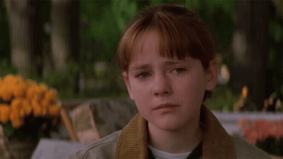 A Girl With Red Hair And A Brown Jacket Looks Down GIF