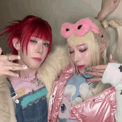 A Girl With Red Hair And A Girl With Blonde Hair Are Posing For A Photo GIF