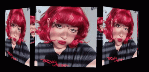 A Girl With Red Hair And A Striped Shirt Has A Reflection Of Herself In A Mirror GIF