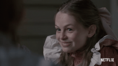 A Girl With Red Hair And Freckles Is Smiling In A Netflix Ad GIF