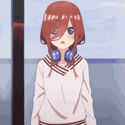 A Girl With Red Hair And Headphones Around Her Neck Is Standing In Front Of A Window . GIF