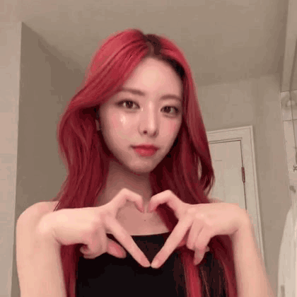 A Girl With Red Hair Is Making A Heart With Her Hands . GIF