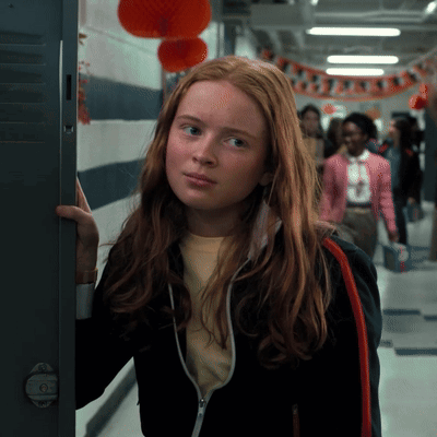 A Girl With Red Hair Is Standing In A Hallway GIF