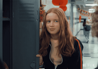 A Girl With Red Hair Is Standing In Front Of A Locker With Netflix Written On It GIF