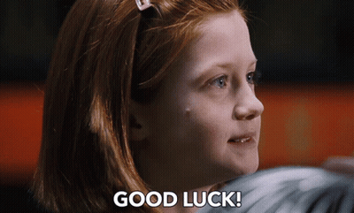 A Girl With Red Hair Says " Good Luck " In Front Of Her Face GIF