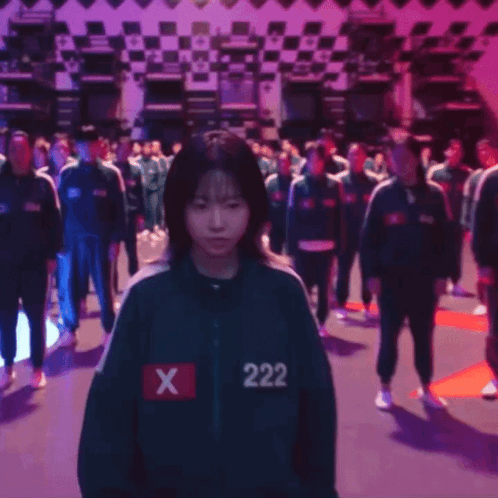 A Girl With The Number 222 On Her Jacket Stands In A Crowd GIF