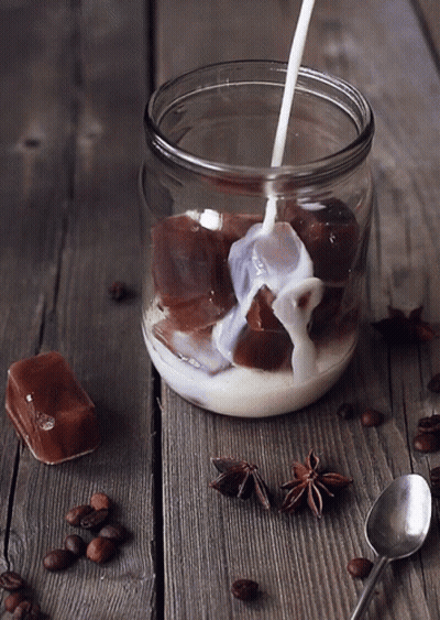 A Glass Jar Filled With Milk And Ice Cubes GIF
