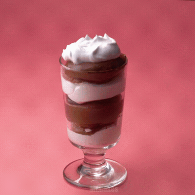 A Glass Of Chocolate Mousse With Whipped Cream On Top Of It GIF
