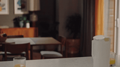 A Glass Of Orange Juice Sits On A Counter Next To A Pitcher Of Orange Juice GIF
