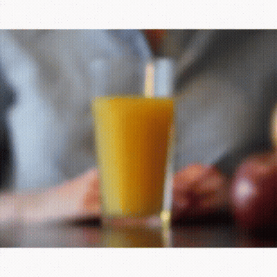A Glass Of Orange Juice With A Straw In It GIF