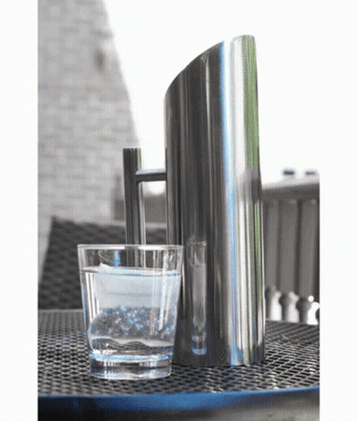 A Glass Of Water Sits Next To A Pitcher On A Table GIF