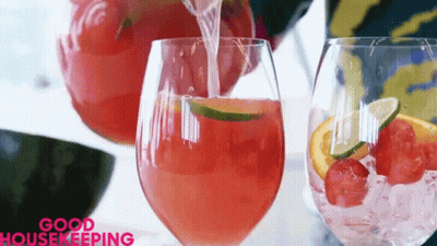 A Glass Of Watermelon Juice Is Being Poured From A Pitcher GIF