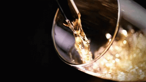 A Glass Of Wine Is Being Poured Into A Wine Glass GIF
