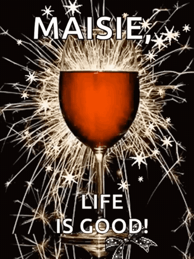 A Glass Of Wine With Fireworks In The Background And The Words `` Maisie , Life Is Good '' GIF