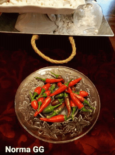 A Glass Plate Filled With Red And Green Peppers With Norma Gg Written On The Bottom GIF
