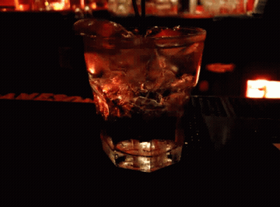 A Glass With A Straw In It Sits On A Bar Next To A Sign That Says Mrs. GIF