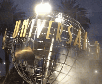 A Globe With Universal Written On It Is Lit Up At Night GIF