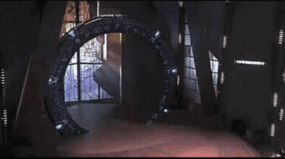A Glowing Light Is Coming Out Of A Portal In The Middle Of A Room . GIF